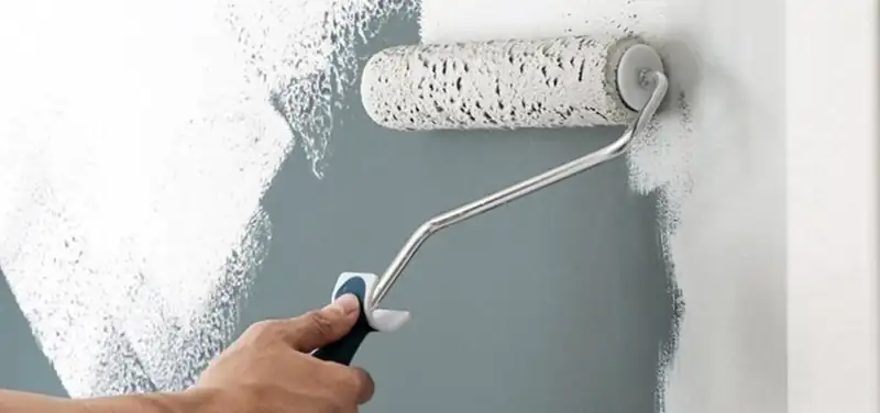 Peinture au rouleau sur un mur gris-bleu